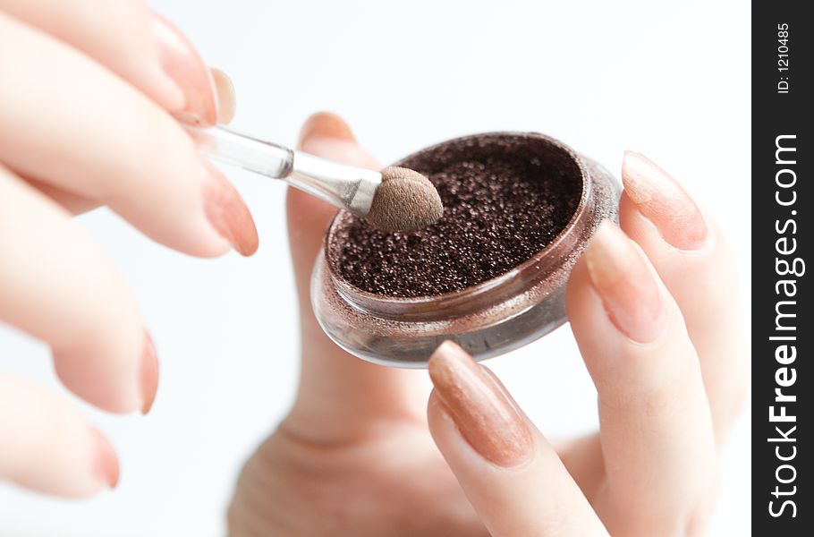 Purple eyeshadow in hands on white background