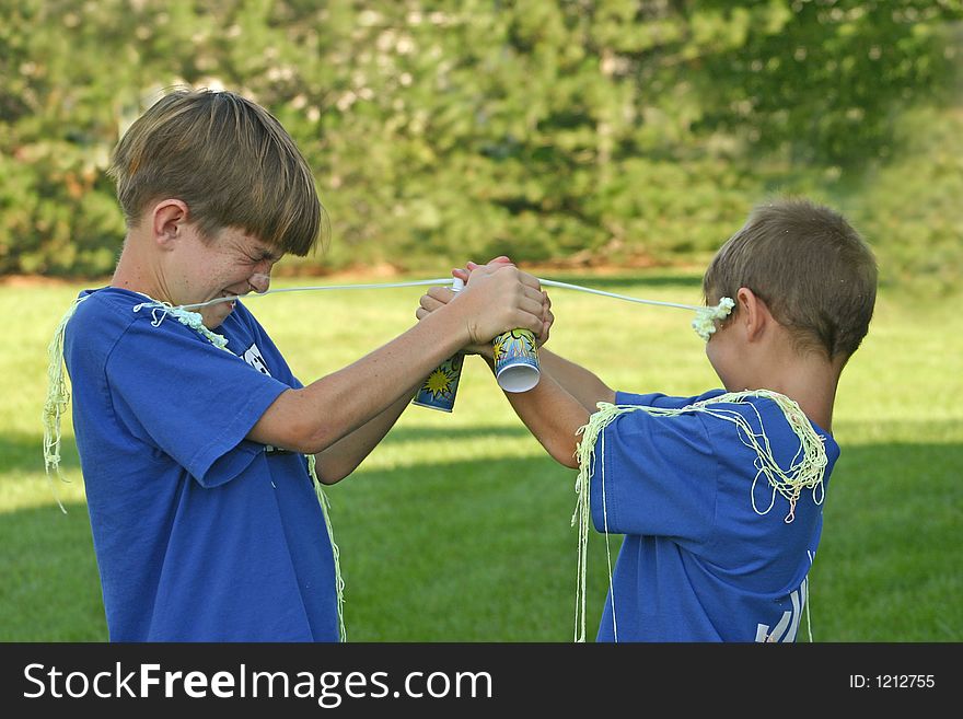 Boys having fun shooting string at each other. Boys having fun shooting string at each other