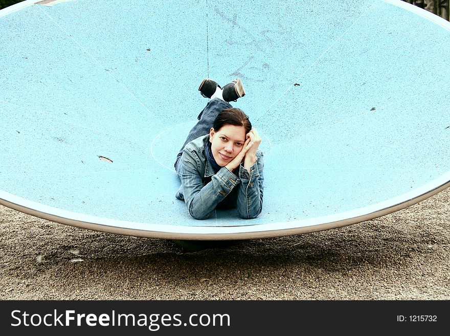 Young woman laying on a blue basin wich is part of a playground. Young woman laying on a blue basin wich is part of a playground