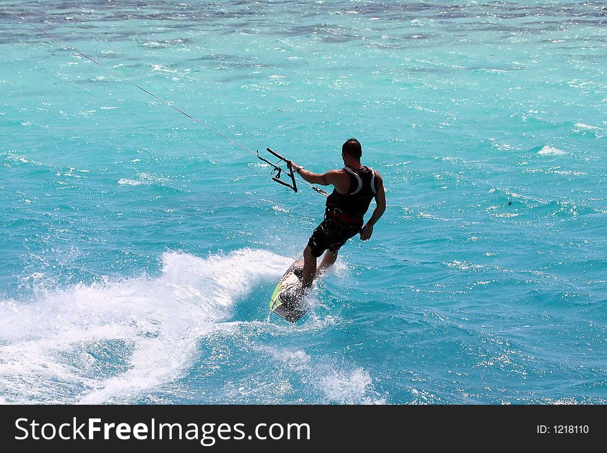 Kitesurfer downwind on a colorful lagoon