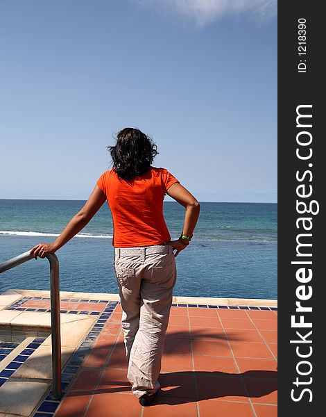 Young woman looking at sea in a tropical resort hotel. Young woman looking at sea in a tropical resort hotel