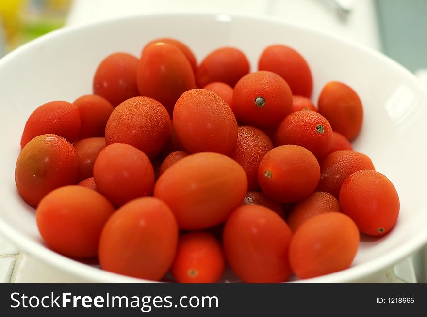 Baby tomatoes on white bowl - closeup