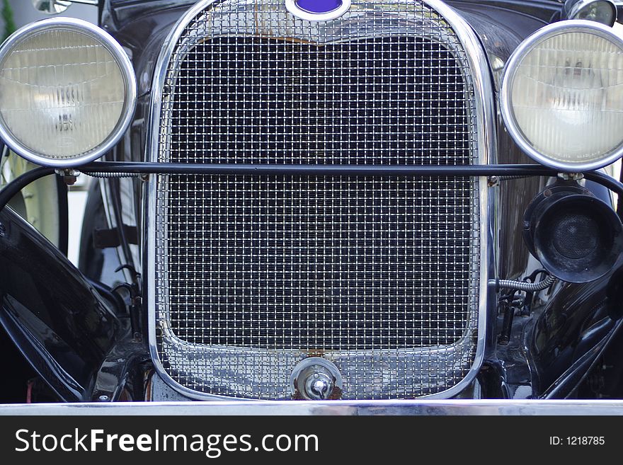 Close up of a shiny, black antique car.