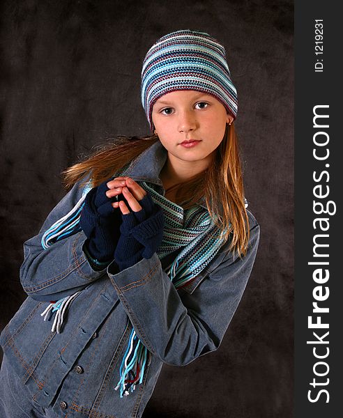 Portrait of the girl in a winter cap, gloves and a scarf. Portrait of the girl in a winter cap, gloves and a scarf