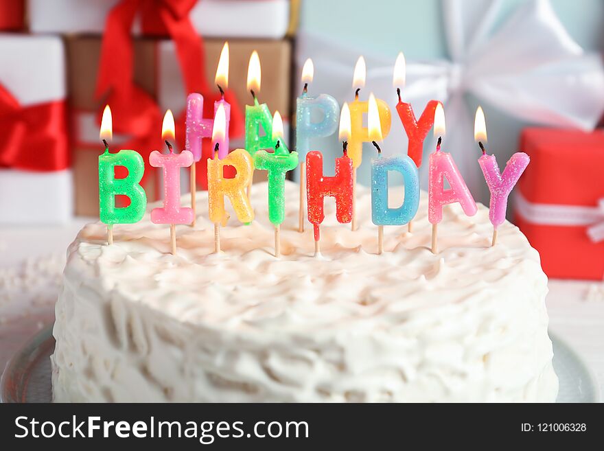 Delicious birthday cake with burning candles, closeup