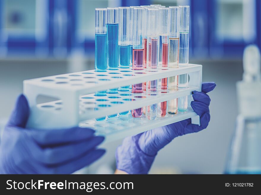 Female chemist holding pack of test tubes