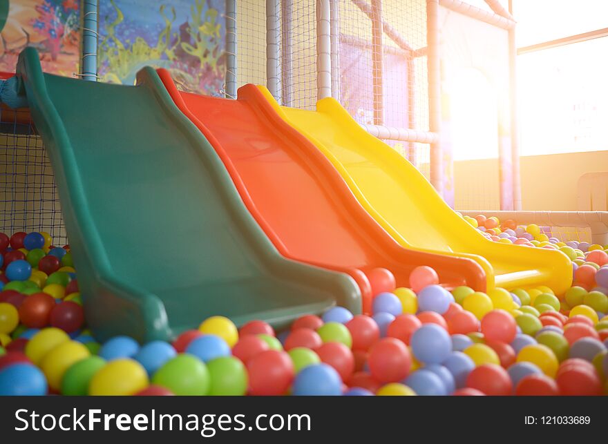 Children playground with plastic slides and colorful balls in po