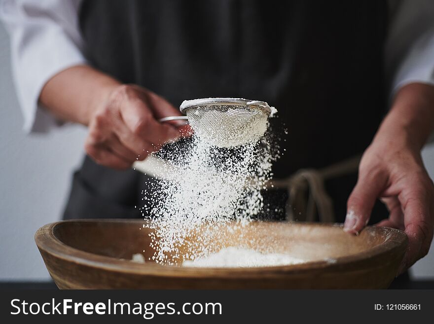 Female Hands Sifting Flour To Bowl.