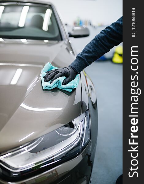 A man cleaning car with cloth, car detailing or valeting concept. A man cleaning car with cloth, car detailing or valeting concept.