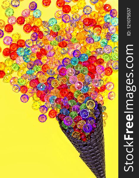 Ice cream cone with multicolored beads on a yellow background