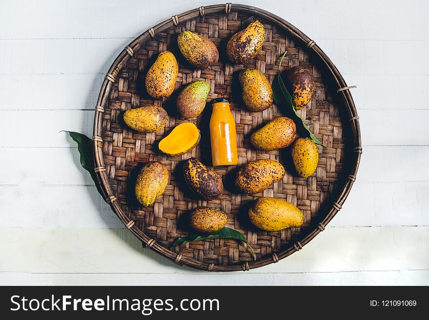 Nature mango In threshing basket On a wooden table and a white cloth