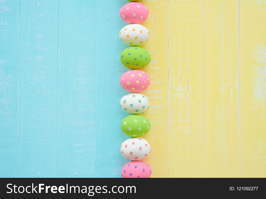 Happy easter! Row Easter eggs with colorful paper flowers on bright blue and yellow wooden background. Happy easter! Row Easter eggs with colorful paper flowers on bright blue and yellow wooden background.