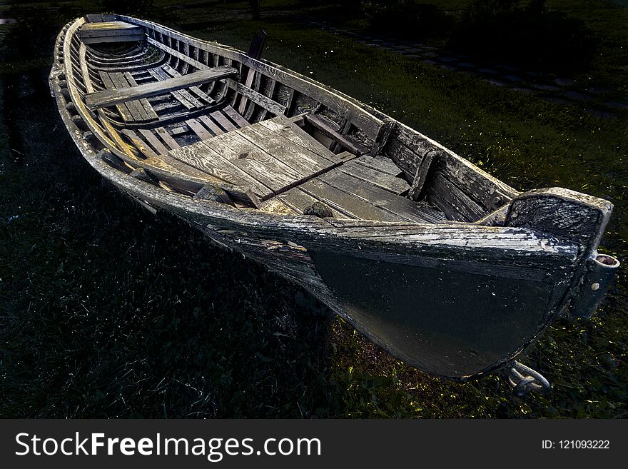 An old wooden fishing boat left on the shore. An old wooden fishing boat left on the shore