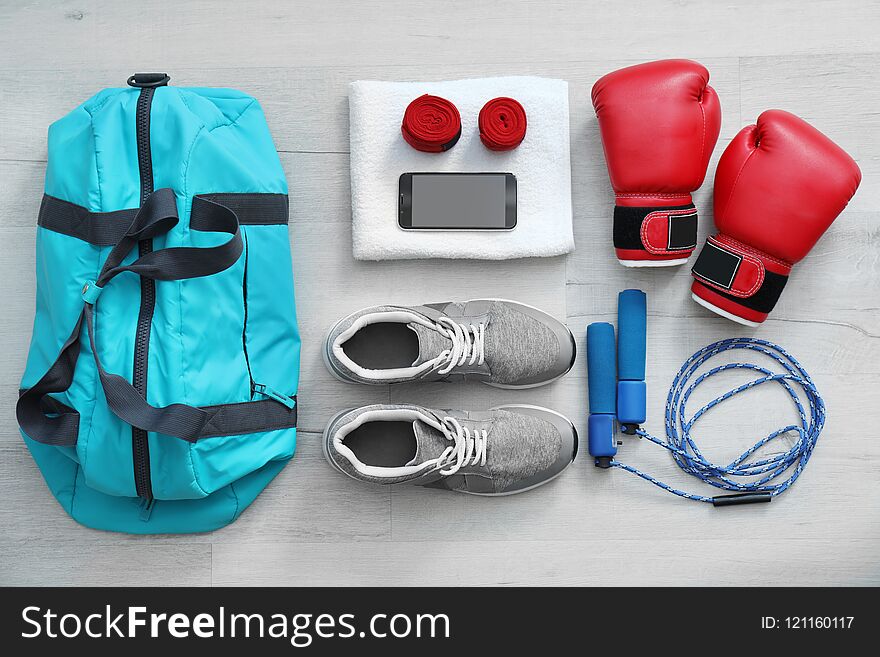 Flat lay composition with sports bag on wooden floor