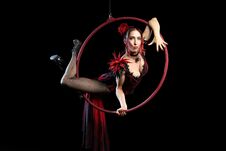 A Adul Girl In Red Evening Dress Performs The Acrobatic Elements In The Air Ring On A Black Background. Stock Images A Adul Girl In Red Evening Dress Performs The Acrobatic Elements In The Air Ring On A Black Background. Stock Images