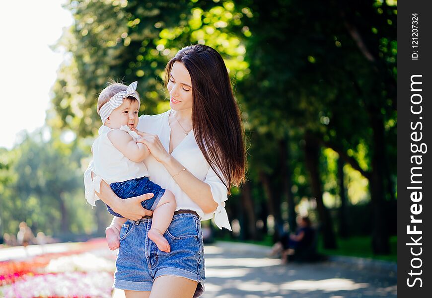 Mother with 8 month baby girl spend time in a park. Mother with 8 month baby girl spend time in a park