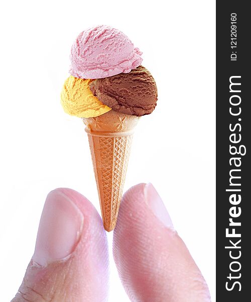 Handing holding a miniature ice cream cone with assorted flavoured scoops. Handing holding a miniature ice cream cone with assorted flavoured scoops
