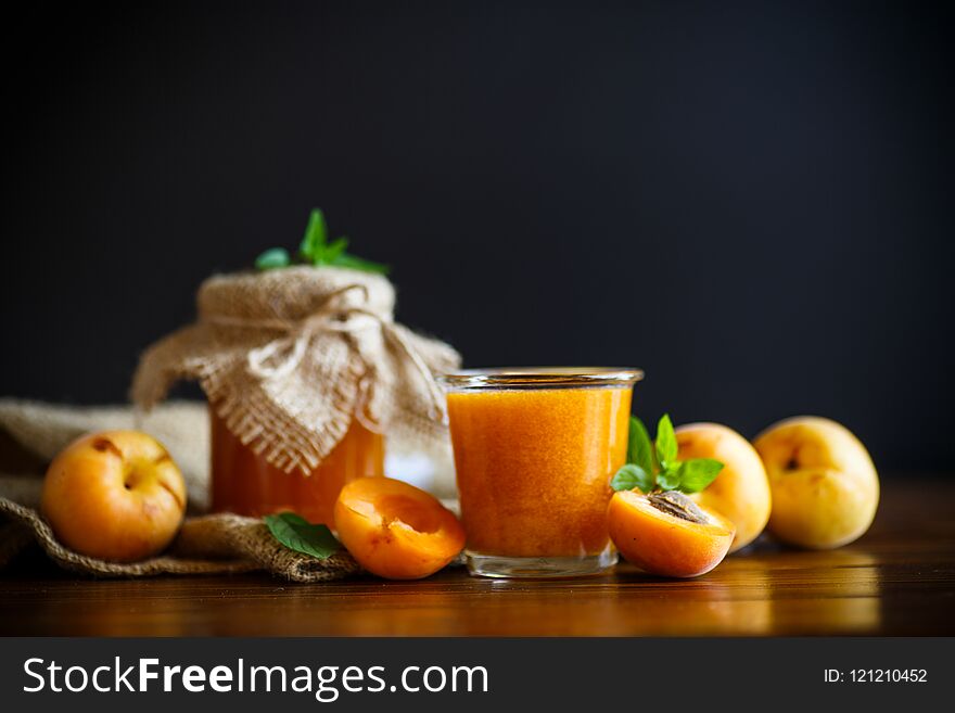 Fresh sweet apricot jam isolated on a wooden table