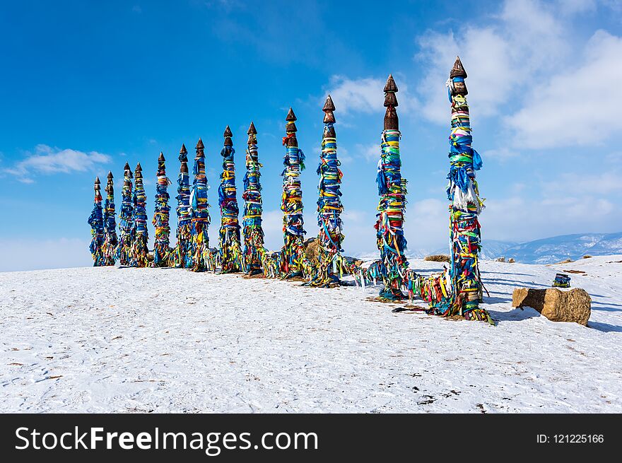 Wooden ritual pillars with colorful ribbons on cape Burkhan, Lake Baikal, Olkhon Island, Siberia, Russia