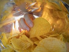 Hand Taking Potato Chips Inside The Bag Stock Photos