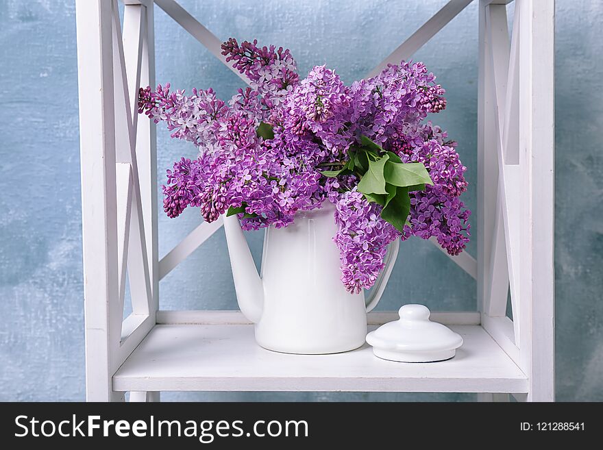 Pot with blossoming lilac on shelf