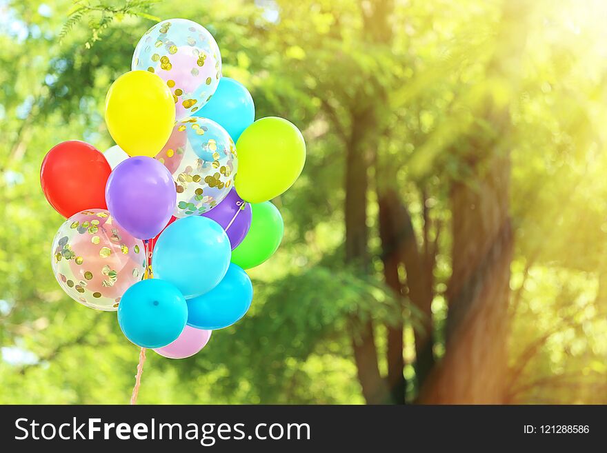 Many colorful balloons outdoors on sunny day