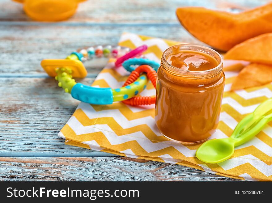 Jar with healthy baby food on table