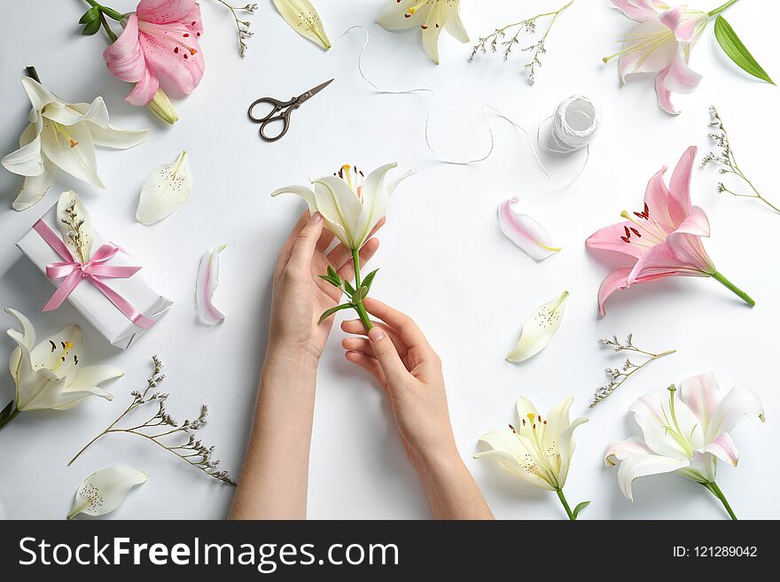 Woman with beautiful lily flower on white background, top view