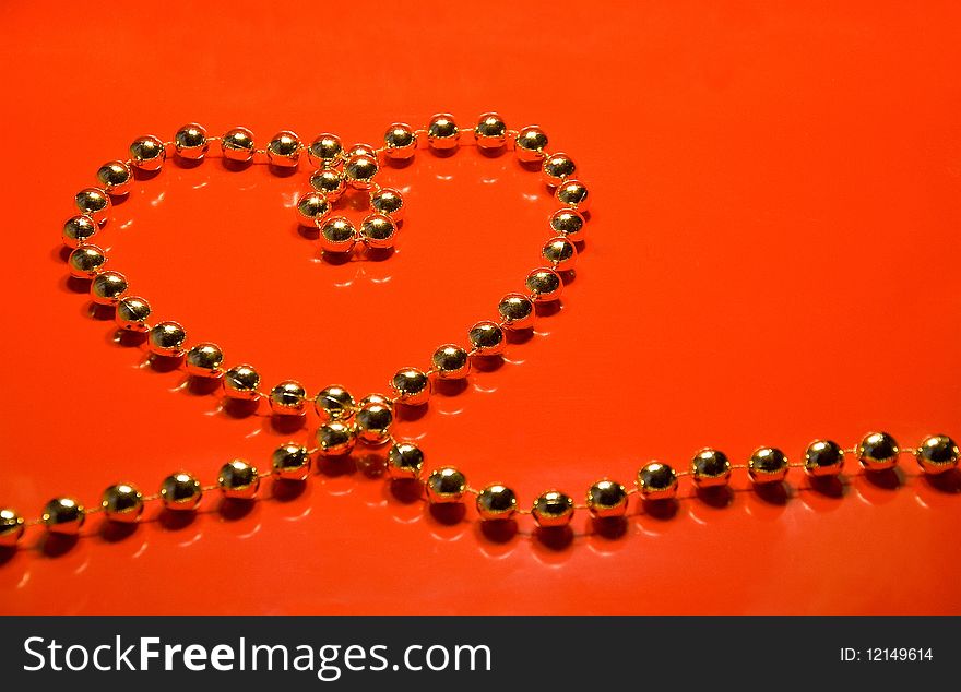 Heart from beads on a red background