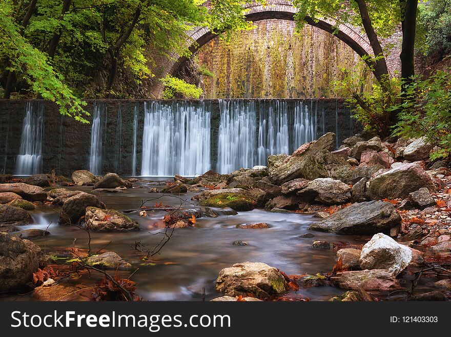 Paleokarya, old, stone, arched bridge, between two waterfalls. Trikala prefecture Thessaly Europe Greece.