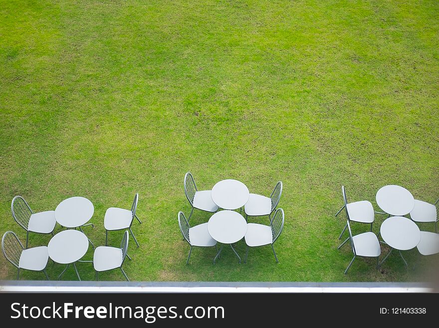 Top view of table and chairs on garden terrace at cafe.