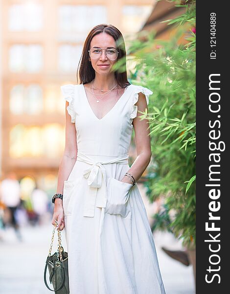 Happy woman walking in european street. Portrait of young attractive tourist outdoors. Happy woman walking in european street. Portrait of young attractive tourist outdoors