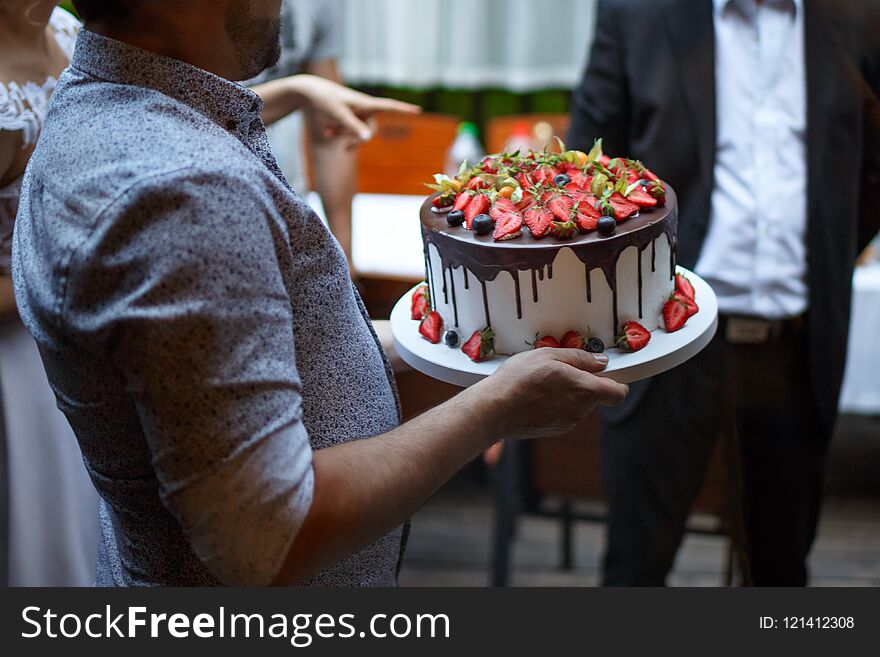 A Man Bears A Beautiful Cake At Celebration.