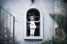 Happy Cute Little Girl Smiling And Standing By The Window Stock Photos