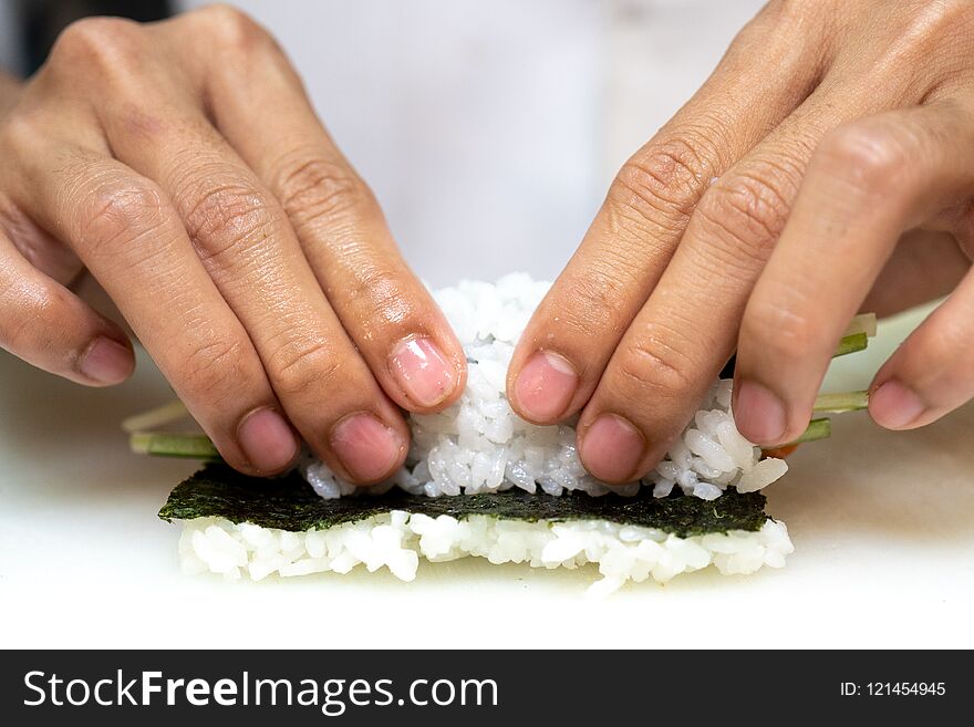 Closeup of chef hands preparing japanese food.