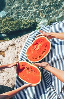 Two Pairs Hands Takes Watermelon Halfes From Striped Cover Royalty Free Stock Image