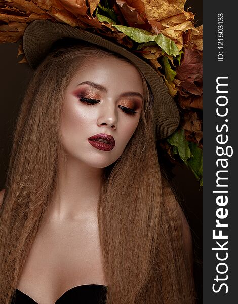Beautiful blond model in autumn hat : curls, bright makeup, red lips. The beauty face.