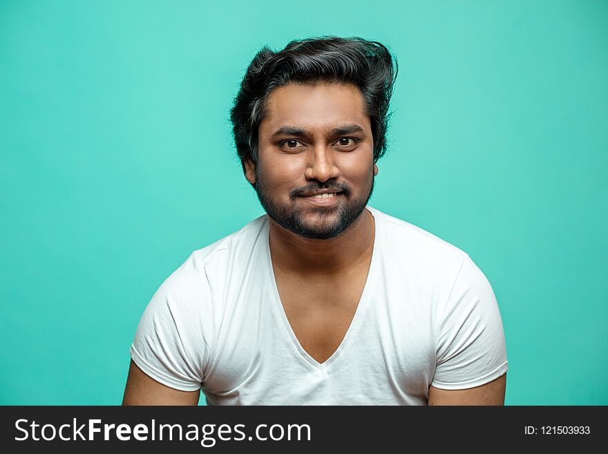 Close up portrait of cunning Indian male pretending that he is smiling