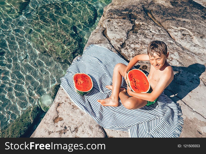 Summer plesuares: boy ready to eat big watermelon after swimming