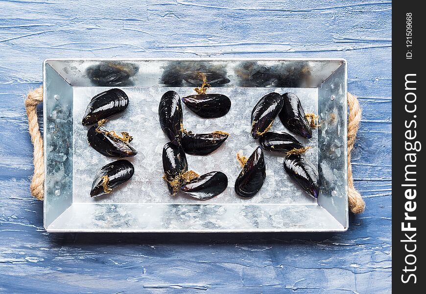 Word Sea written with raw mussels on a silver tray. Word Sea written with raw mussels on a silver tray