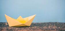 Yellow Paper Folded, Origami, Boat On Blue Background Stock Photo