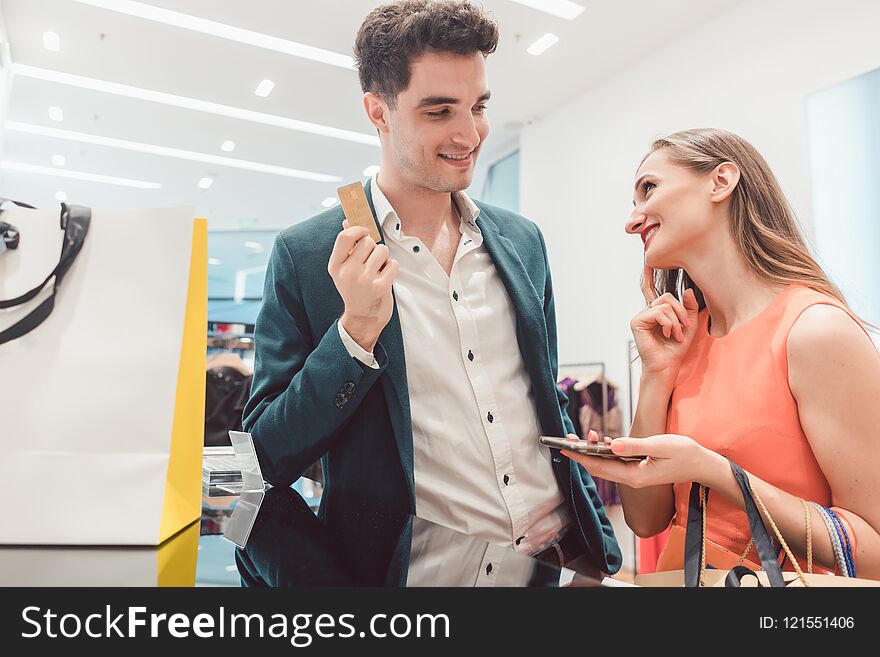 Man having to pay with credit card for fashion items for his wife