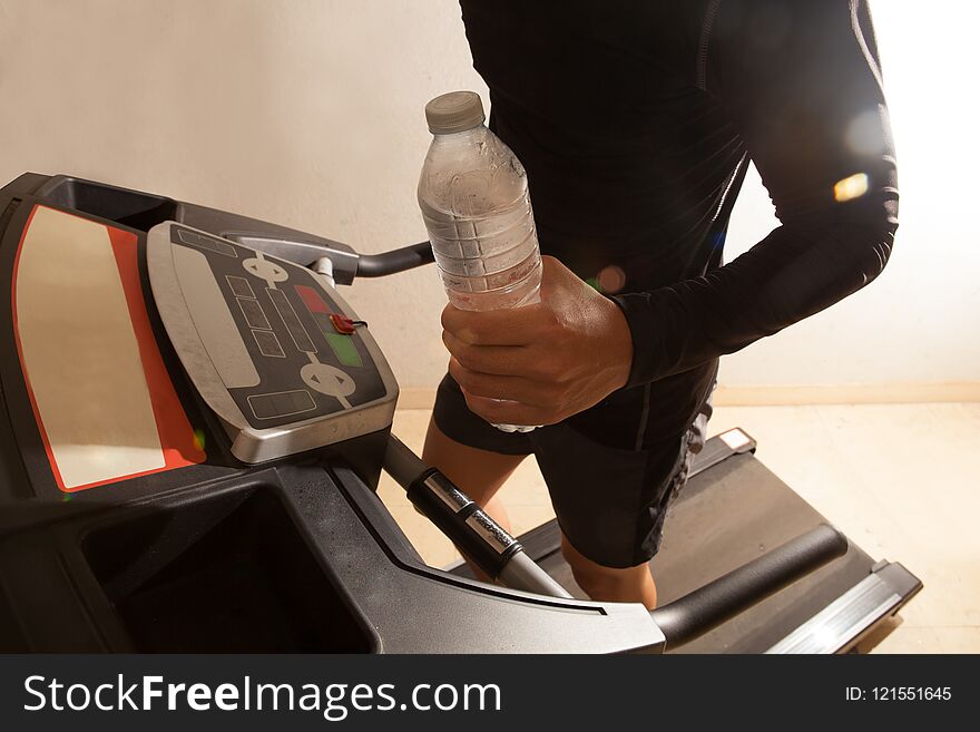 Man running on treadmill in fitness with water. Man running on treadmill in fitness with water