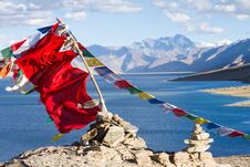 Buddhist Prayer Flags On The Wind Against The Blue Lake, Mountains And Sky Stock Photos
