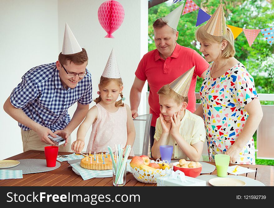 Colorful portrait of happy big family celebrate birthday and grandparents blows candles with their children. Colorful portrait of happy big family celebrate birthday and grandparents blows candles with their children