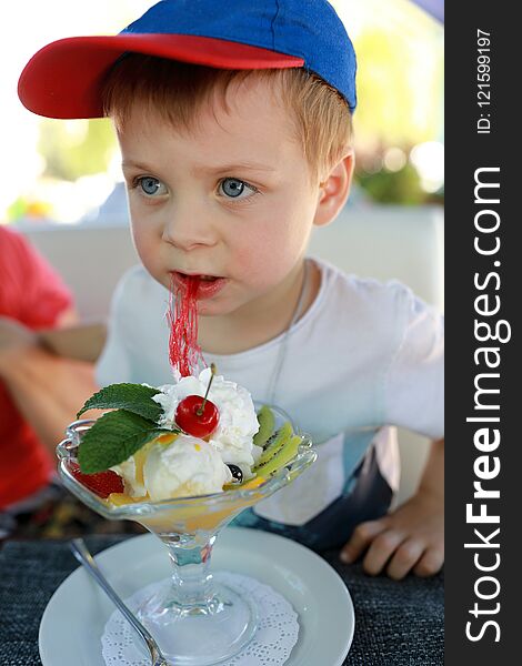 Child eating dessert at table in cafe