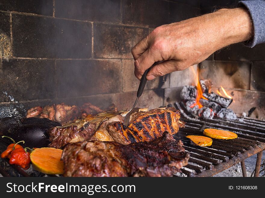 Man Making Barbecue For The Lunch. Traditional Argentinian Bbq.