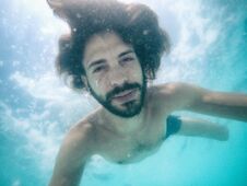 Attractive Young Man Submerged In Pool Looking At Camera Royalty Free Stock Images
