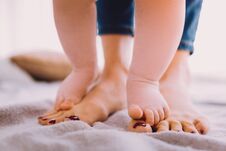 Cute Baby Standing On The Feet Of A Mother And Finding Balance Stock Images