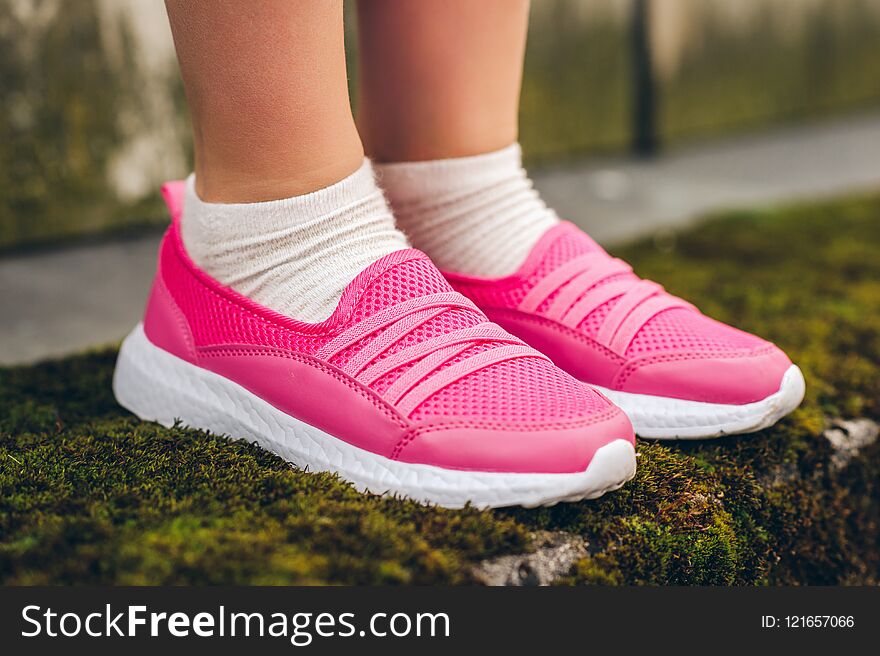 Close up image of pink modern sneakers wearing by a girl